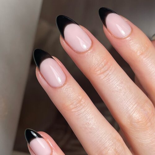 Almond-shaped nails with shiny black French tips and a natural base.