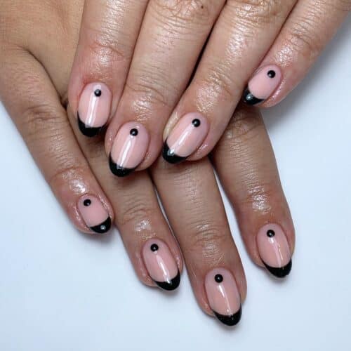 Rounded nails with glossy black French tips on a translucent pink base.