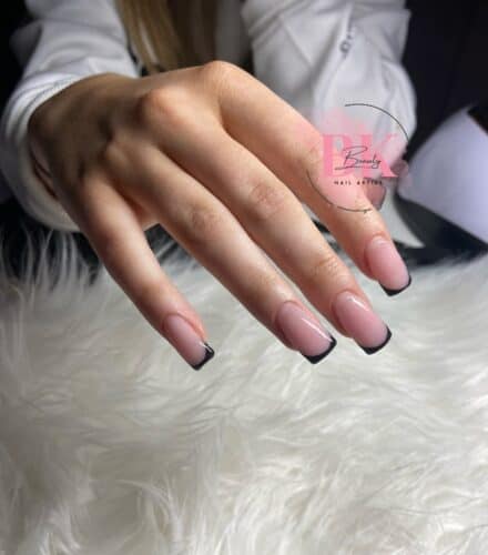 Square nails with a neat black French tip over a pinkish-nude base.