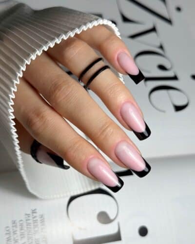 Square-shaped nails with a soft pink base and striking black French tips, embodying modern elegance.