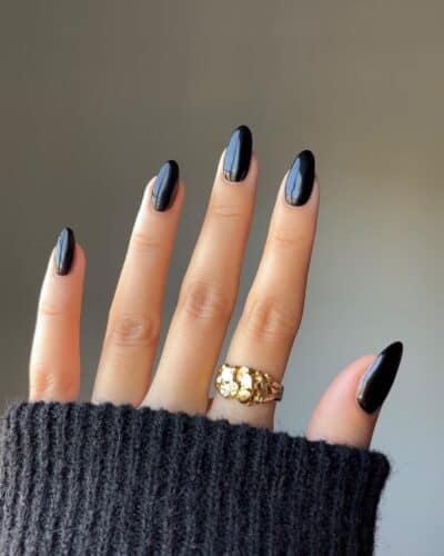 Glossy black gel nails with a perfect curve, epitomizing sleek and sophisticated elegance.