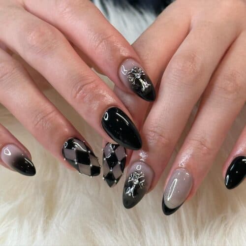Glossy black nails with some nails fully adorned with sparkling jewel embellishments, creating a luxurious and opulent look.