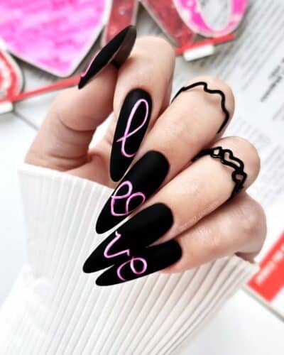 Matte black nails with a bright neon pink outline, adding a playful and modern twist to the classic black.