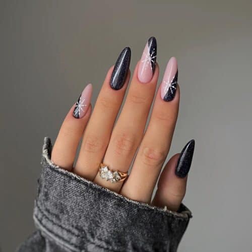 Long almond-shaped nails with a cosmic blend of black, purple, and pink, adorned with white starburst designs.