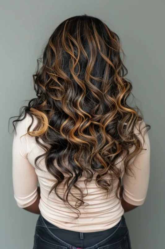 Dark brown hair with blonde and caramel highlights, styled in cascading curls.