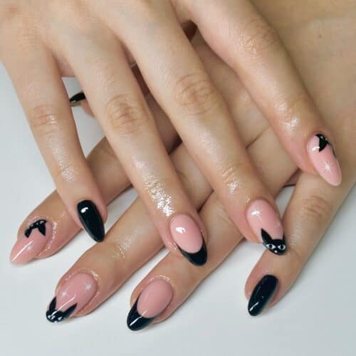 Almond-shaped nails with black French tips featuring cute peeking cat silhouettes, blending elegance with playful charm.
