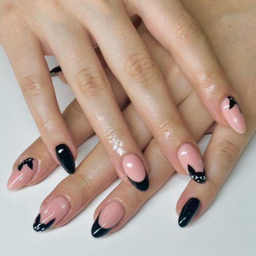 Almond-shaped nails with black French tips featuring cute peeking cat silhouettes, blending elegance with playful charm.