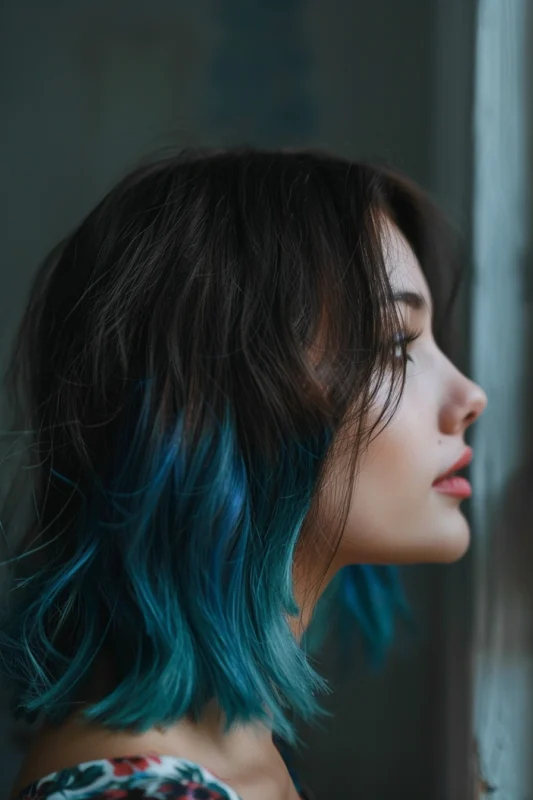 Profile of a woman with dark brown hair that dramatically transitions into bright blue tips.