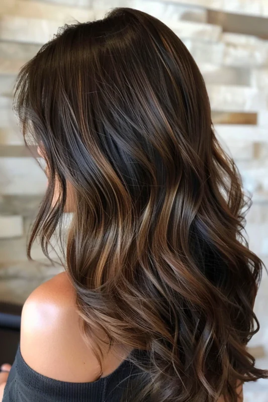 Lush dark brown hair with nuanced brown highlights for added depth.