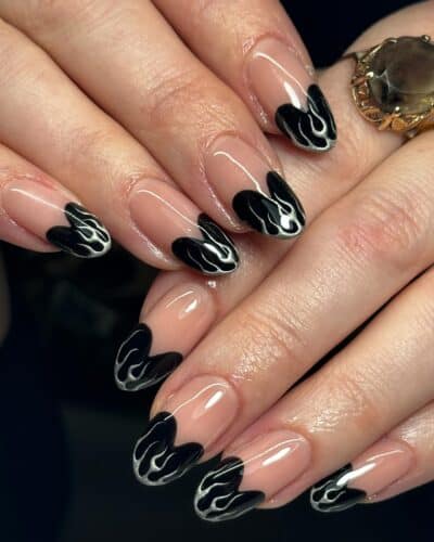 Almond-shaped nails with a black French tip designed to resemble elegant flames.