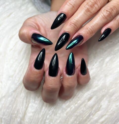 Almond-shaped nails with a metallic black finish that shifts colors, offering an edgy and iridescent appearance.