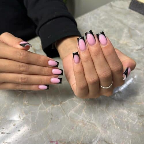 Long square nails with a gentle pink base and a sophisticated black French tip for a modern look.
