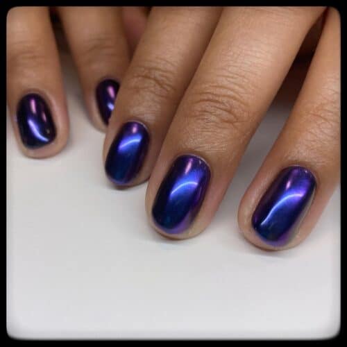 Short, rounded nails with a smooth, iridescent purple metallic finish.