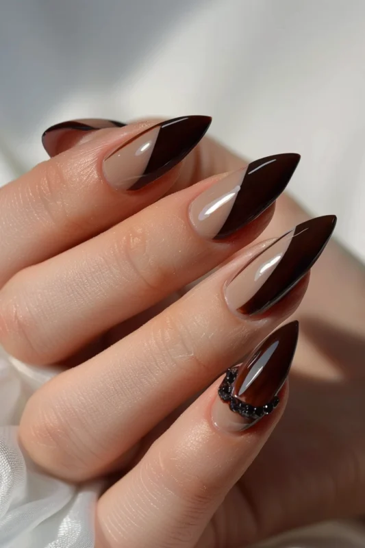 Brown French tip nails with bead accents on one nails.