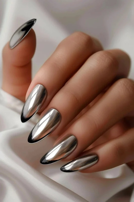 Chrome French tip nails with black accents.