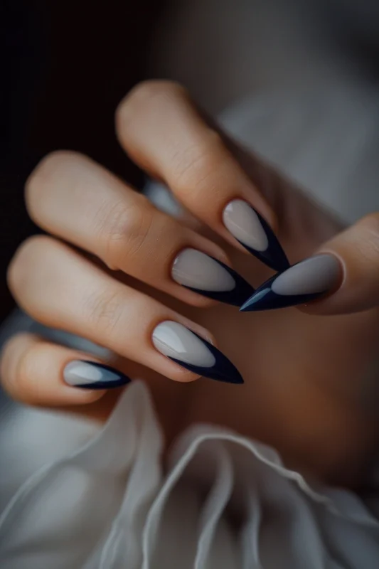 Dark blue and grey French tip stiletto nails.