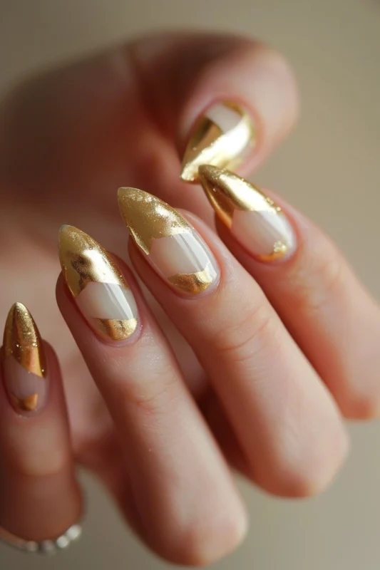 Metallic gold French tip nails on a gentle white base.