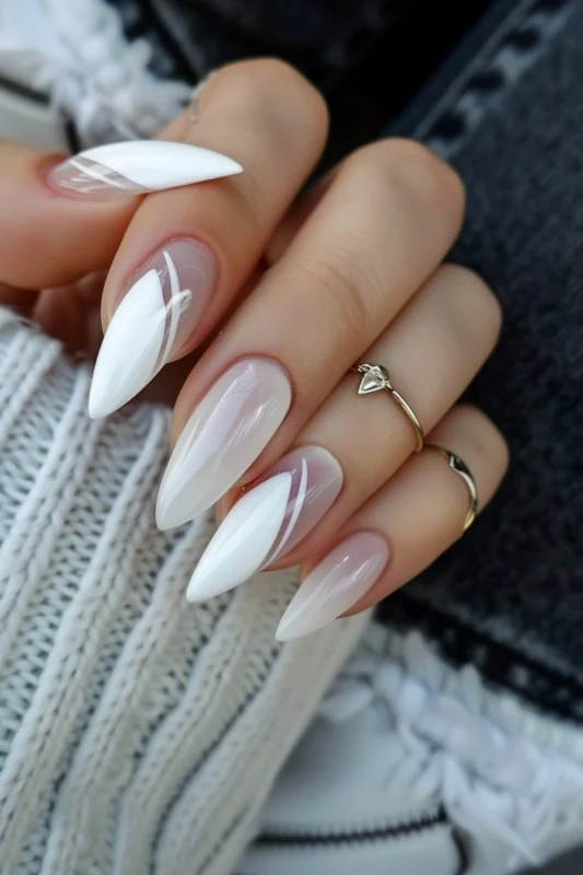 Pointed nails with a sheer base and white abstract design on three of the nails.