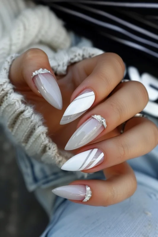 Milky white nails with diamond accents at the base of three of the nails.