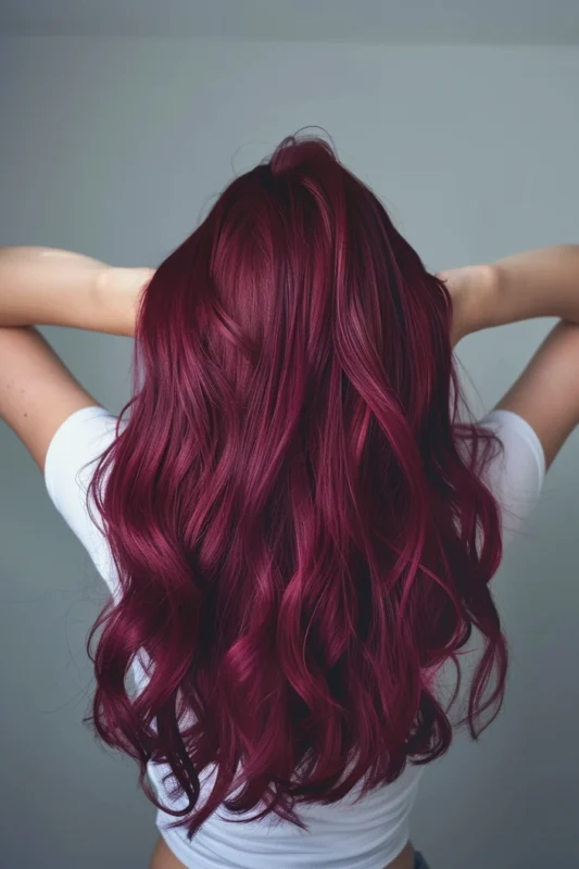 A woman with luxurious waves of mulberry hair color.