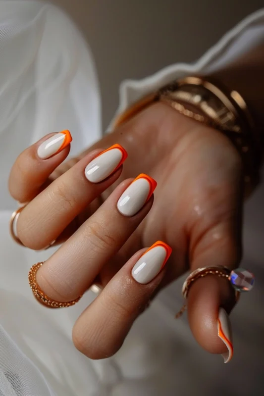 Orange French tips on short square nails.