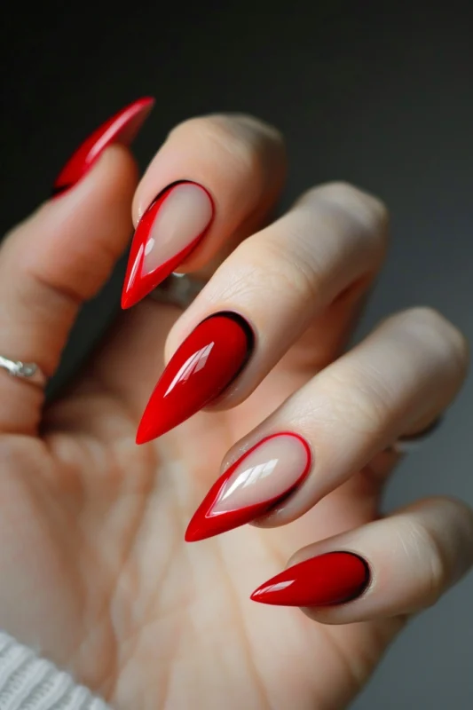 Red stiletto nails with a black outline and red French tips.