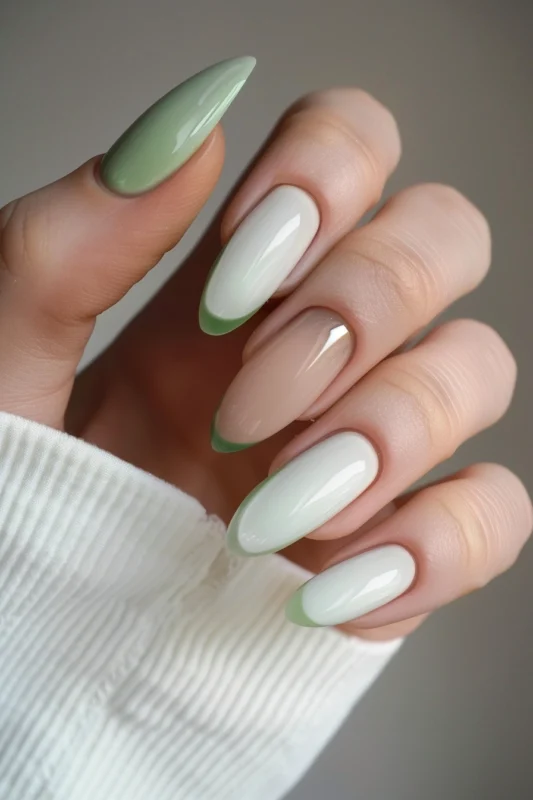 Sage green French tips on long nude and white nails.