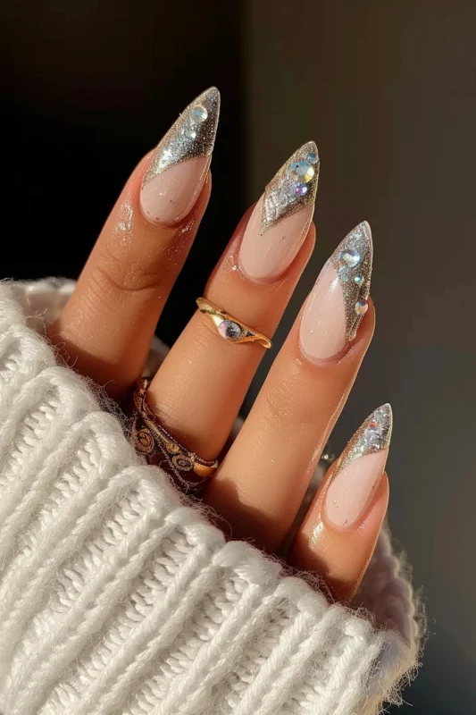 Long almond-shaped nails with silver French tips, glitter, and rhinestones.