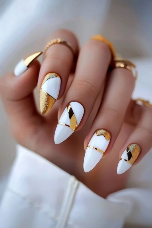 White almond nails with gold glitter and geometric accents.