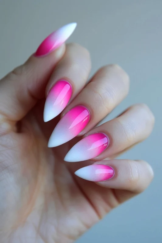Pointy nails with pink to white ombre and subtle glitter.
