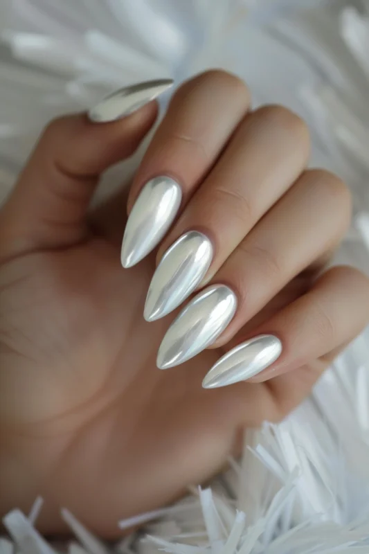 Stiletto nails with a reflective white chrome finish.