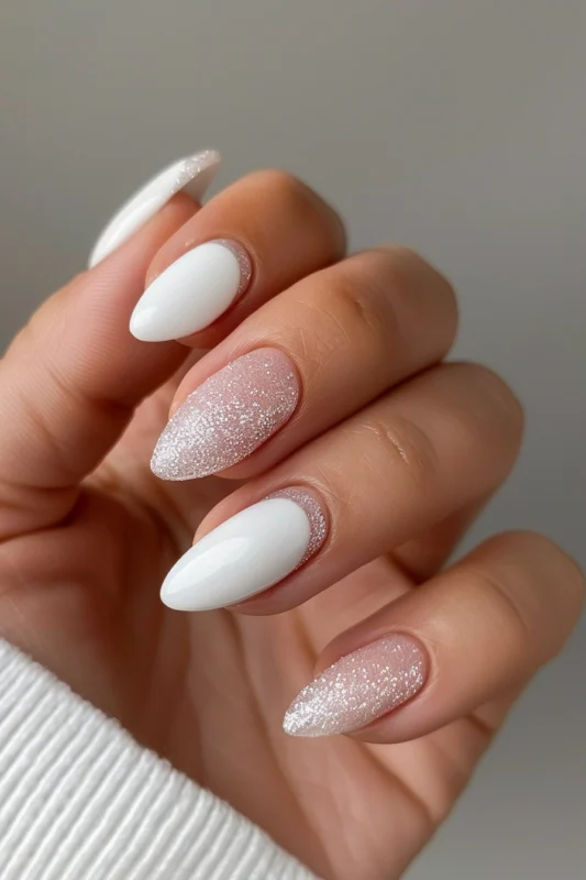 Almond-shaped nails with white base and glitter frosting.