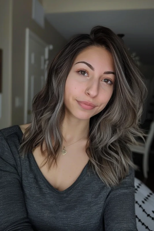 Woman with ash-grey highlights on dark brown hair.