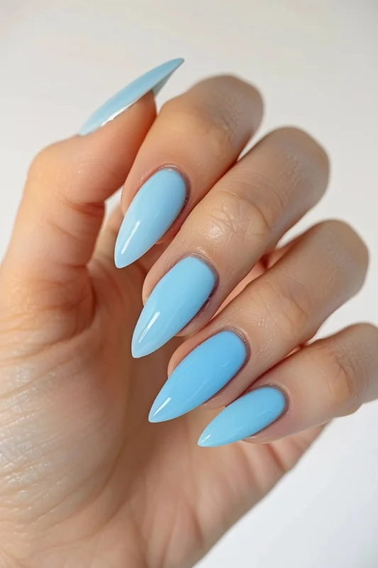 Baby blue stiletto nails with a glossy finish.