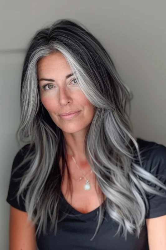 Woman with long, wavy salt and pepper hair.