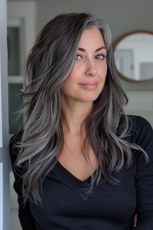 Woman with dark hair and gray streaks.