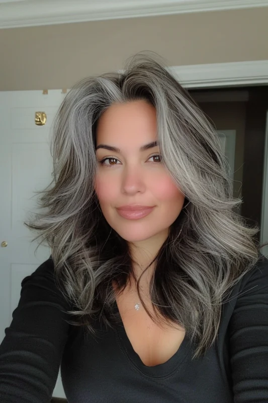 Woman with wavy, voluminous salt and pepper hair.