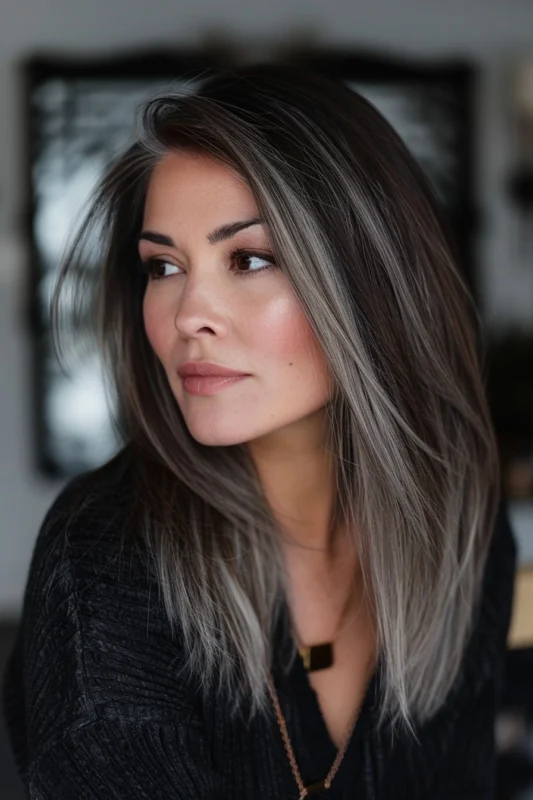 Woman with dark hair featuring subtle and chic silver highlights.