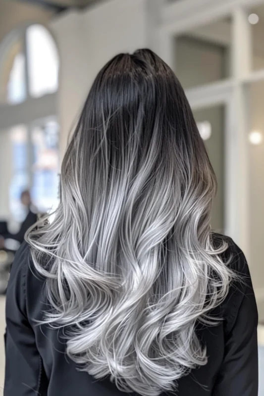 Woman with dark black to silver ombre hair.
