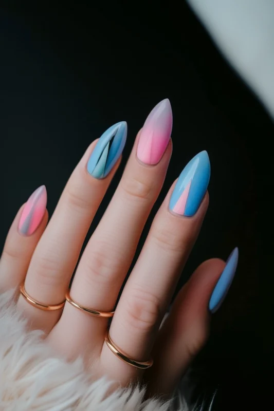 Pointy nails with pink and blue angular French tip designs.