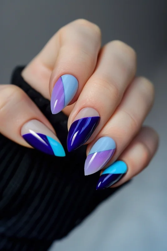 Almond nails with blue to purple gradient and geometric patterns.