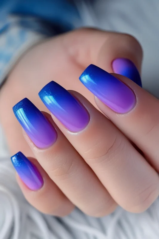 Coffin nails with a purple to blue ombre effect.