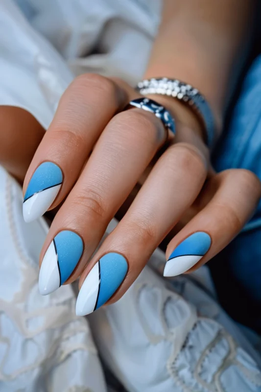 Almond-shaped nails with blue and white French tips and a black line separator.