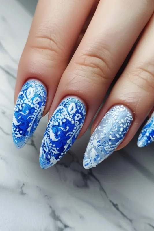 Almond-shaped nails with blue and white porcelain-inspired design.