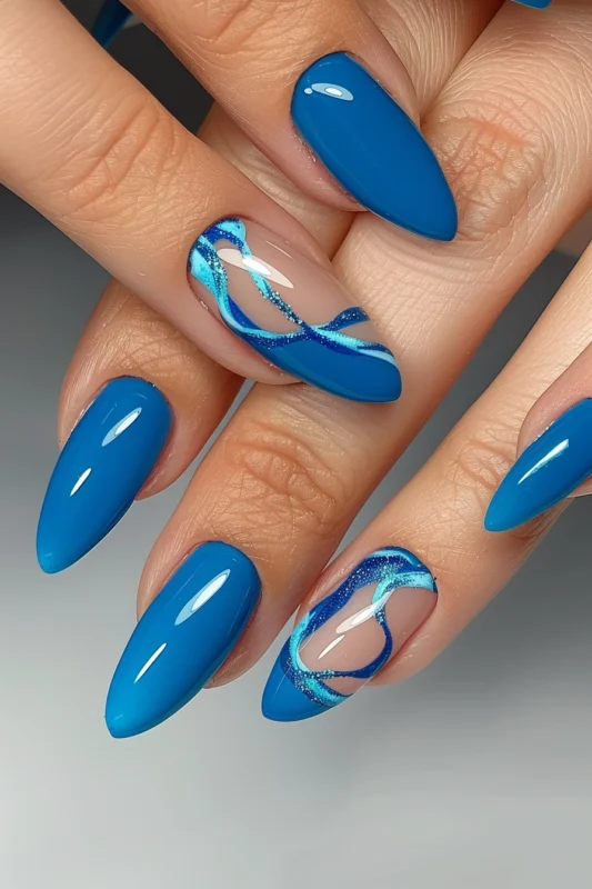 Glossy cobalt blue nails with glittery negative space design on two accent nails.
