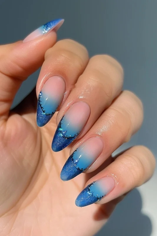 Long almond-shaped nails with blue ombre French tips.