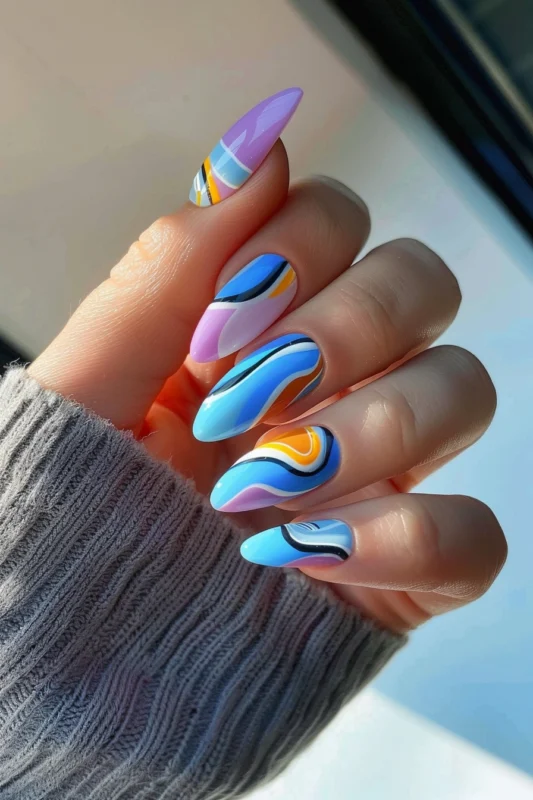 Almond-shaped nails with blue, yellow, and lavender swirl designs.