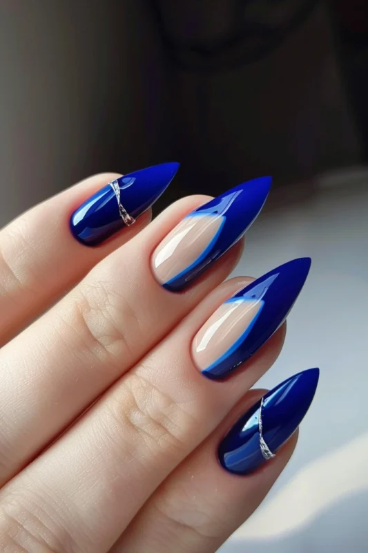 Deep blue French tip accent nails with rhinestone bands on two of the nails.