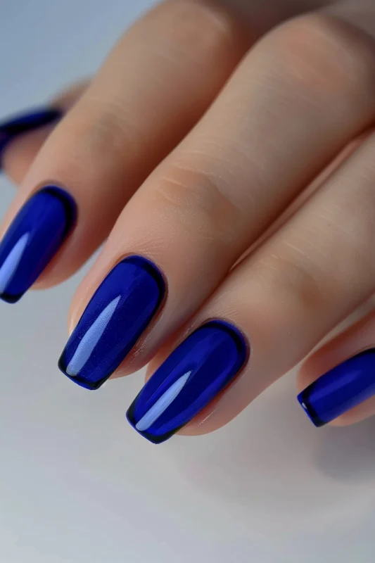 Glossy dark blue nails with a black stripe at the base of each nail.