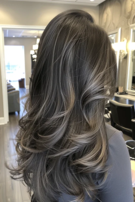 Luxurious gray streaks on long black hair.